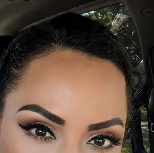 Client selfie showing healed, defined brows